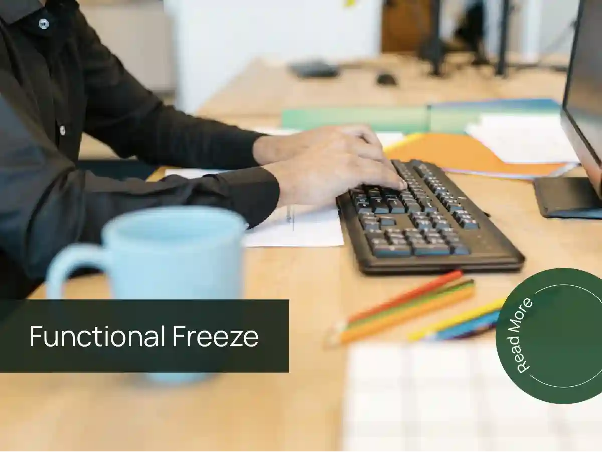 Person typing on a keyboard at a desk with the text “Functional Freeze.”